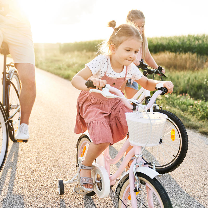 young girl learning to ride a bike